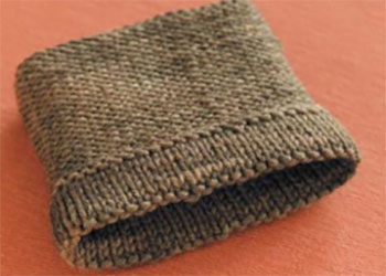 For a cleaner and more polished result, it is recommended to knit the folded hem with needles one size smaller than those used for the main fabric. If the project is worked with yarn held double or with multiple strands, the hem can be knitted with fewer strands to reduce bulk.